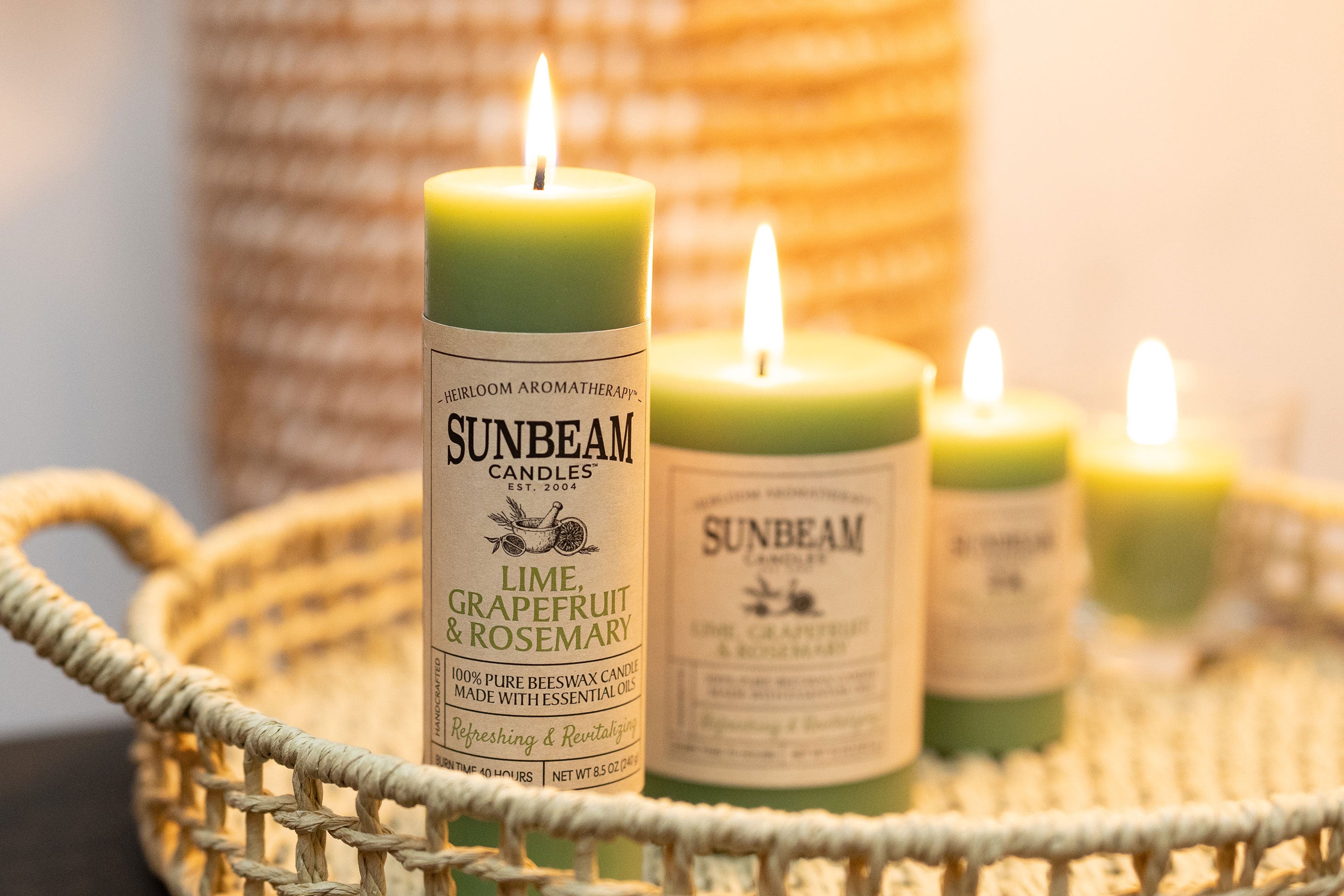 Sunbeam Candles Pure Beeswax Sage Green - Lime, Grapefruit & Rosemary pillar and votive candles sitting in a wicker basket