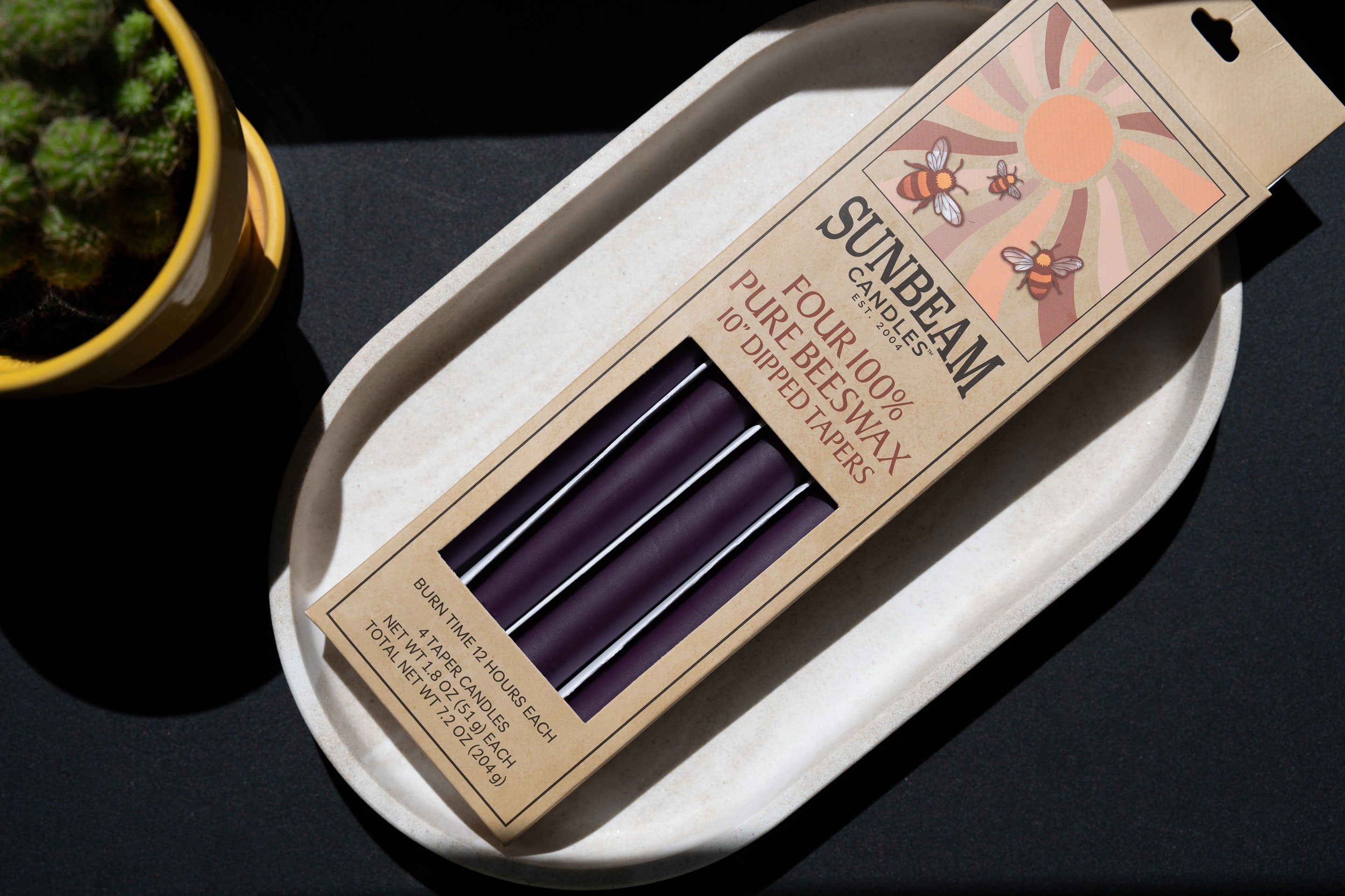 2-pair box of Sunbeam Candles 10" Dipped Beeswax Midnight Black Tapers on a white dish
