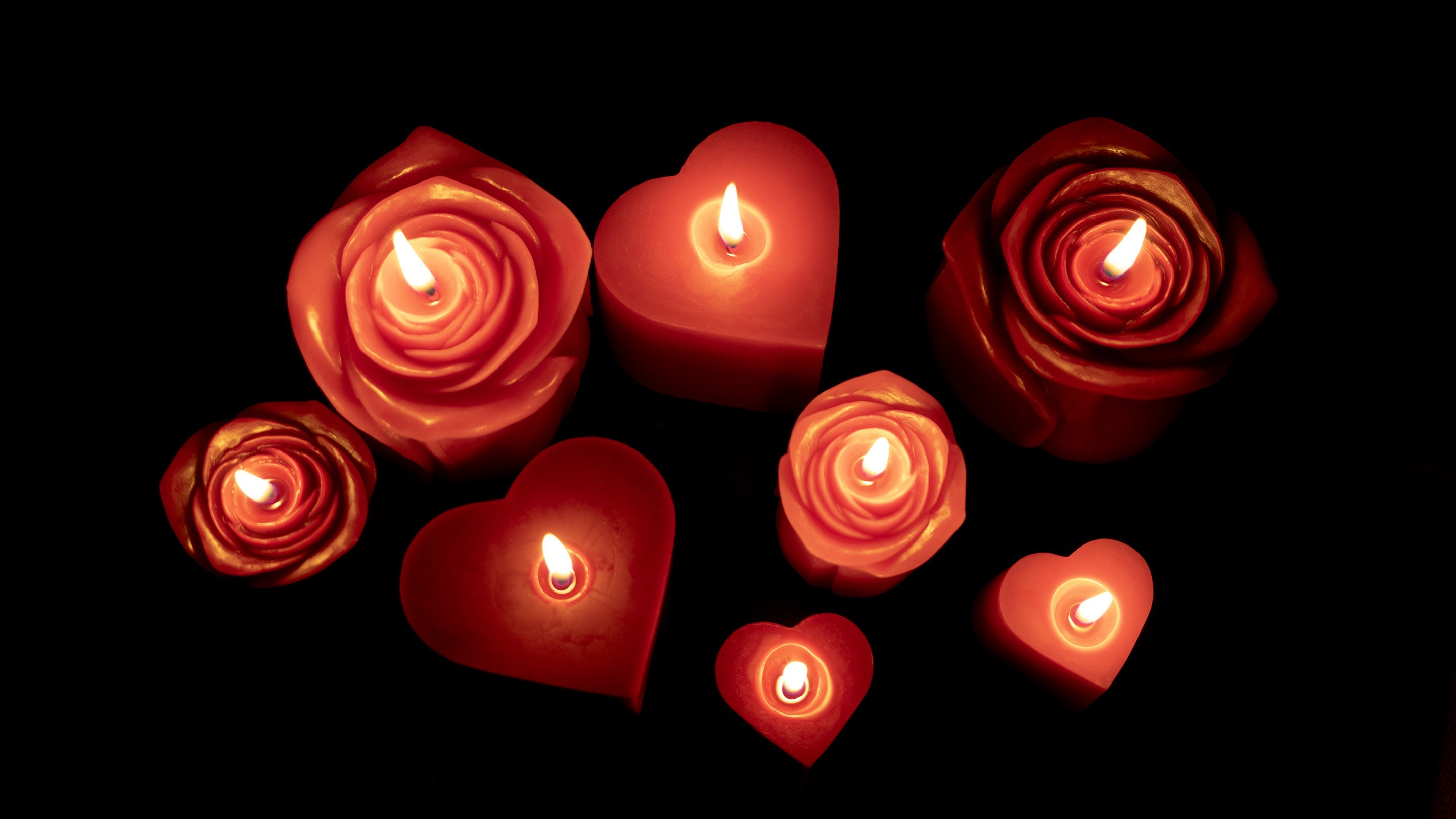 Sunbeam Candles assorted pure beeswax pink & red heart and rose candles lit with view from above and black background