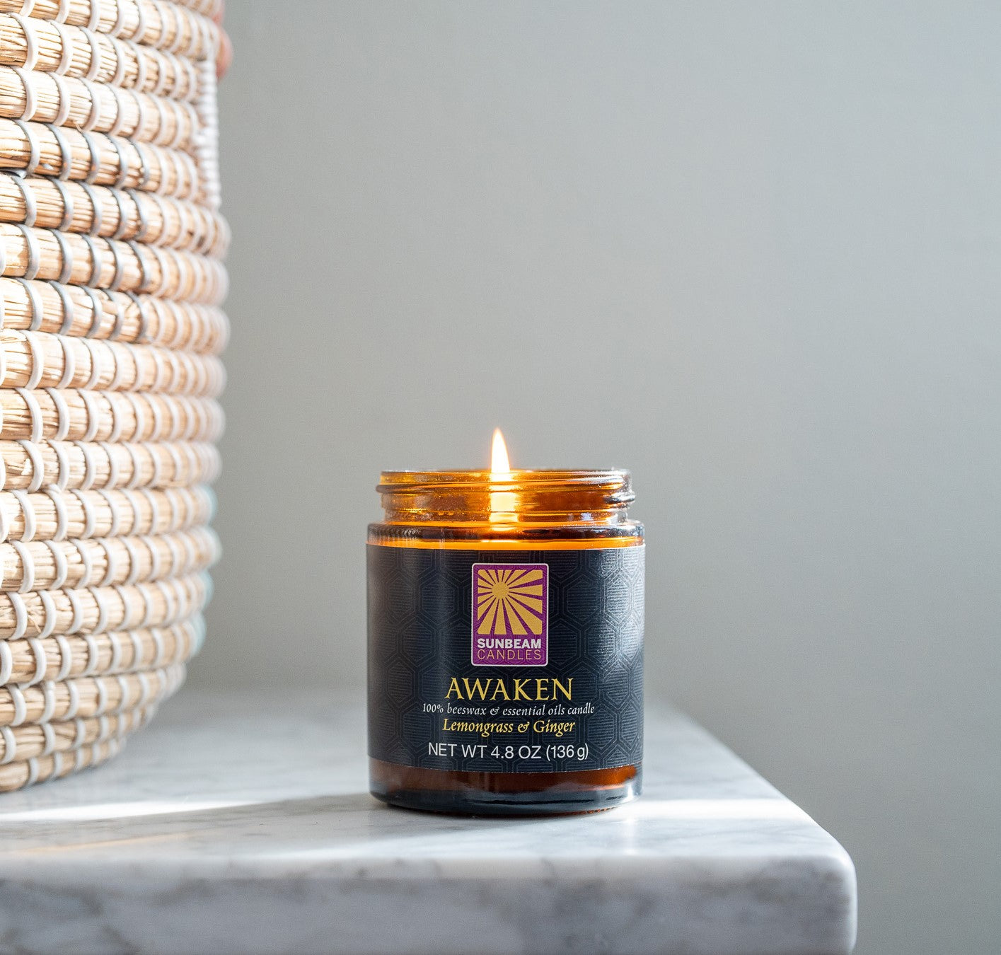 Awaken amber glass aromatherapy jar candle on countertop lit