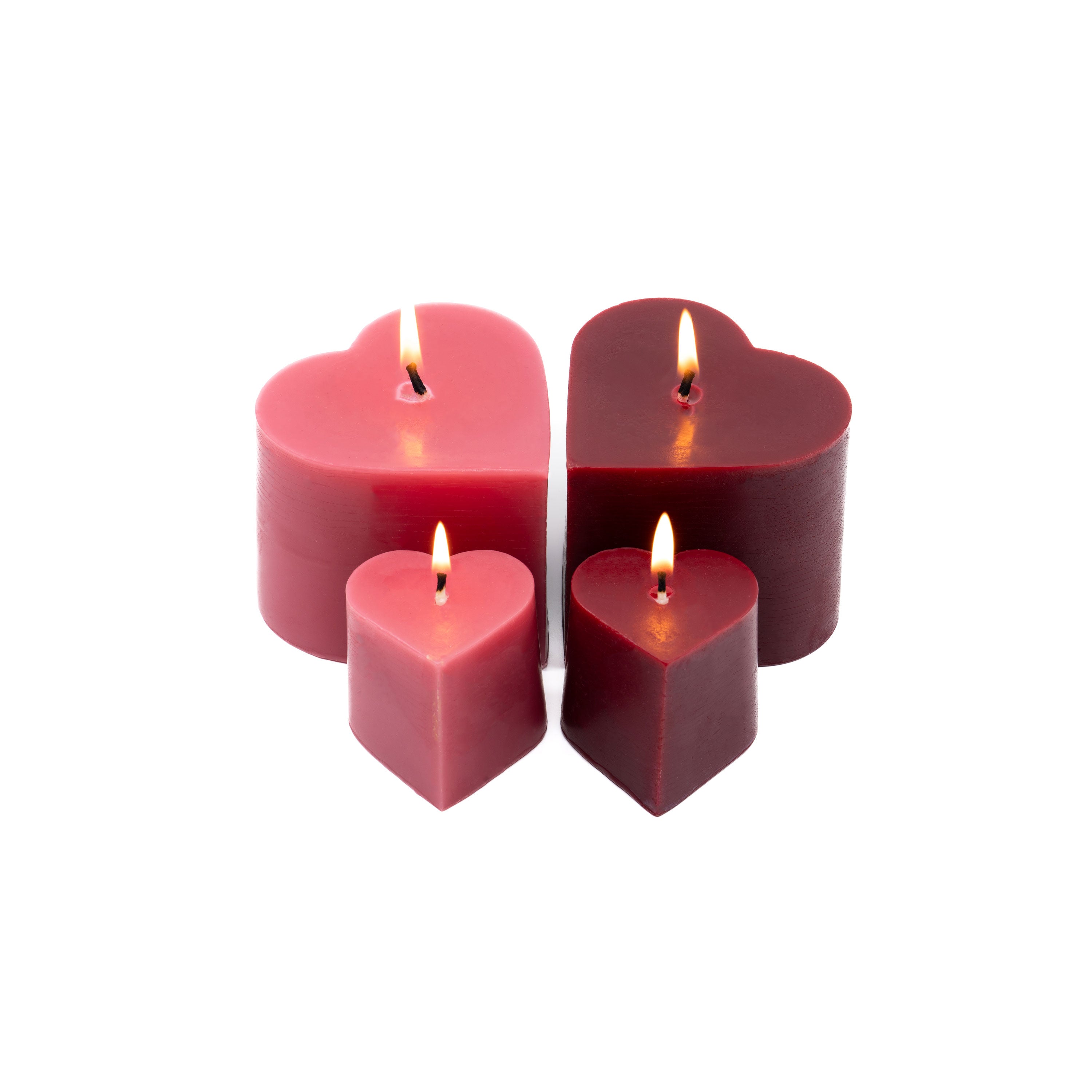Set of lit Sunbeam Candles pure beeswax red & pink heart-shaped candles in various sizes on a white background.