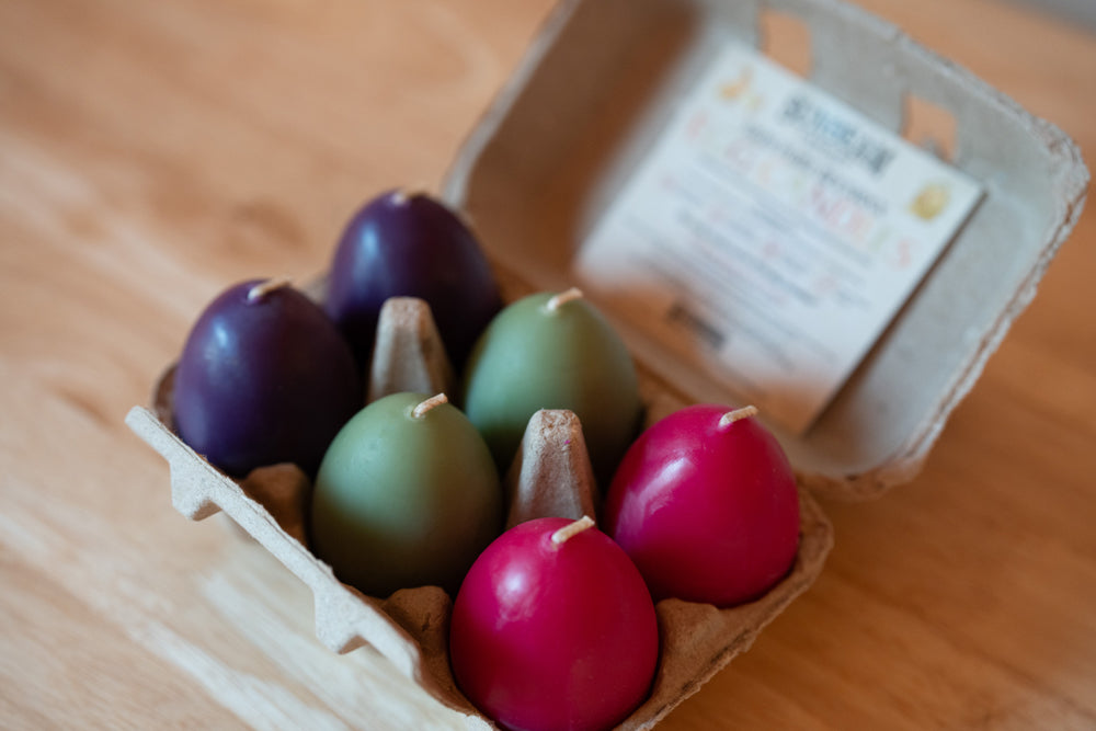 Colorful Easter eggs in a cardboard carton on a wooden surface