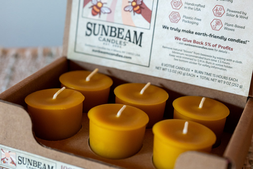 Sunbeam candles in a cardboard box with a label on a wooden surface