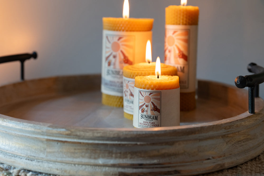 Four sunbeam candles on a wooden tray with a blurred background