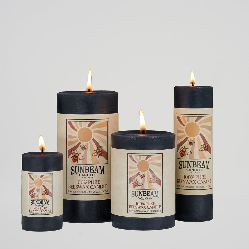 Four lit Sunbeam Candles Smooth Black Beeswax Pillars with a white background.