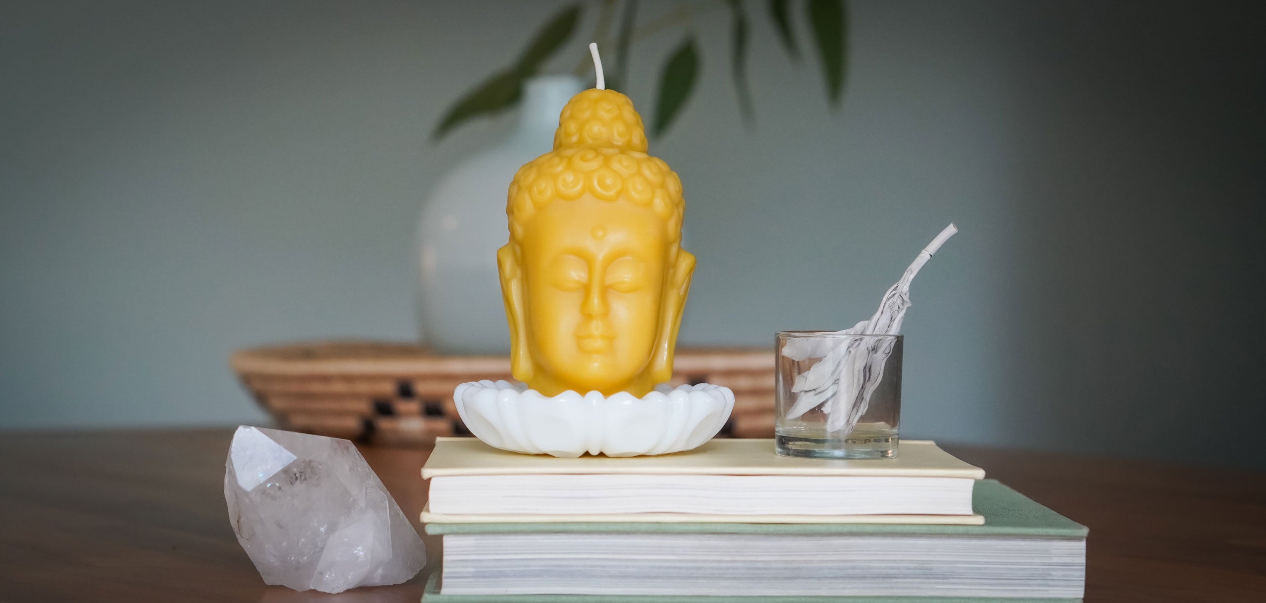 Tibetan Buddha Head candle on books with crystal and sage